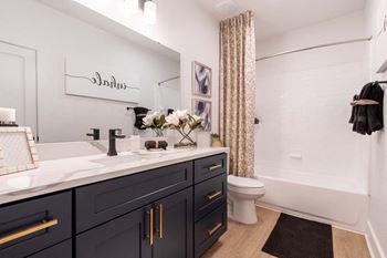 A bathroom with a white sink and a toilet.